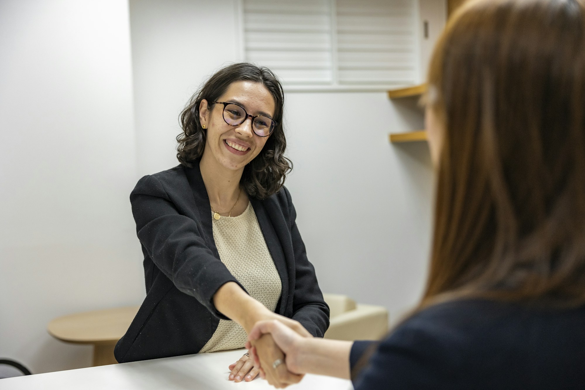 Career consultant shaking hands across a desk