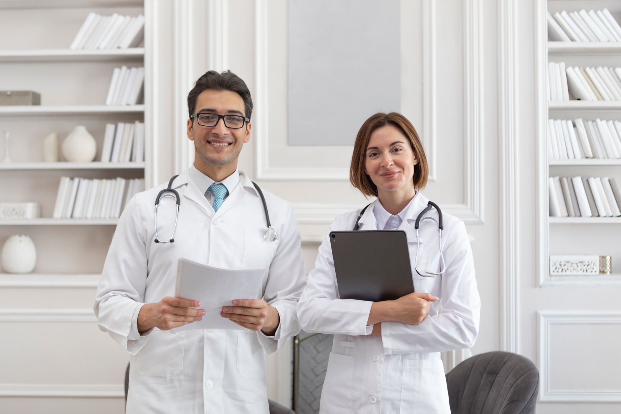 Two physicians smiling in a bright office